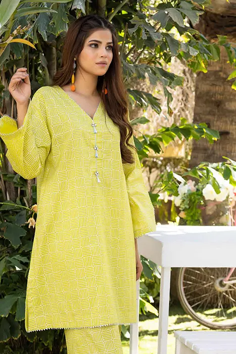 A women Standing in light yellow suit by gul ahmed