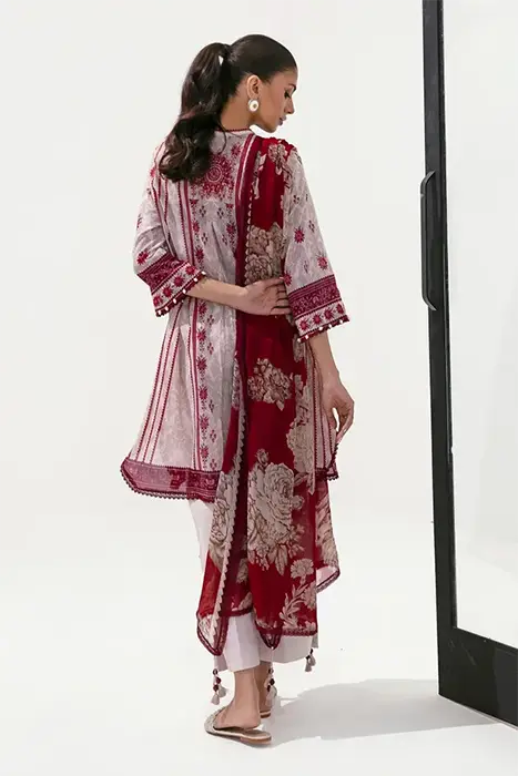 A women sitting in printed Pink Pakistani suit