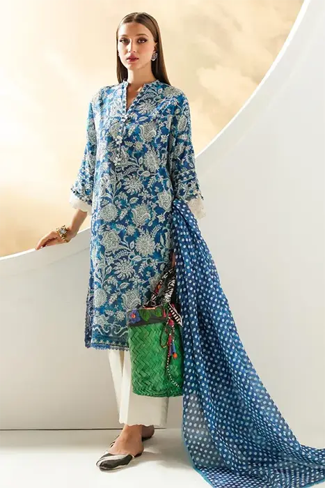 A women sitting in turquoise colour pakistani suit by sana safinaz